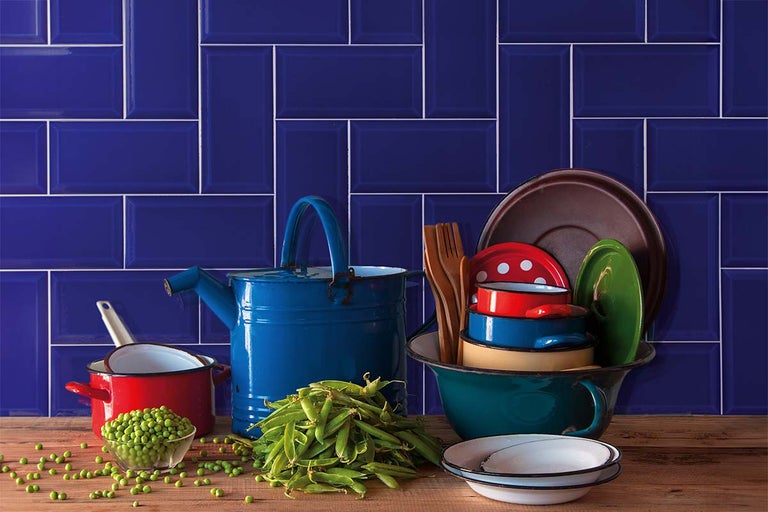 Keukenscène met blauwe tegels, kookgerei en erwten op een houten tafel