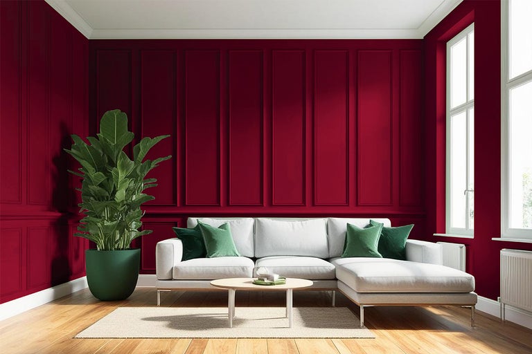 Woonkamer met rode lambrisering, witte bank, kamerplant en houten vloer