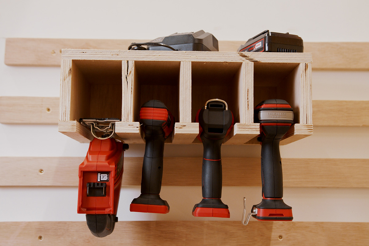 Houten rek met accuschroevendraaiers en opladers voor gereedschapsopslag