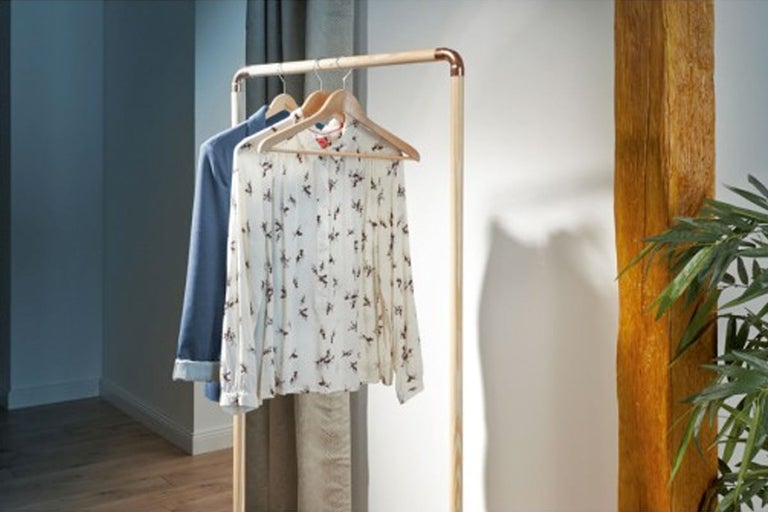 Kledingrek van hout met opgehangen kleding in de kamer