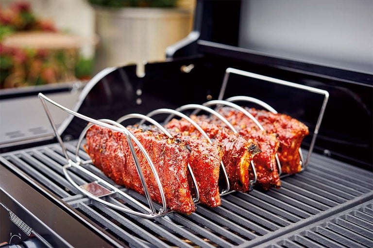 Spareribs in ribhouder op een barbecue