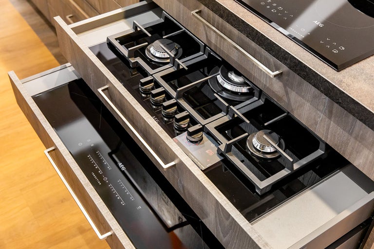 Inbouwkeuken met gasfornuis en inductiekookplaat geïntegreerd in lades