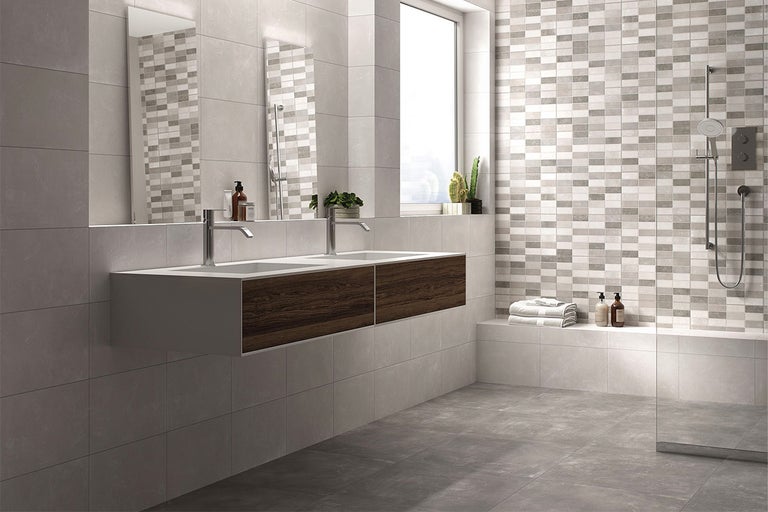 Moderne badkamer met dubbele wastafel, grijze tegels en douche.