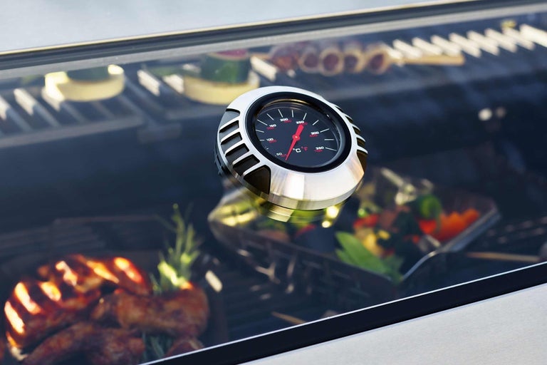 Detailopname van een grillthermometer met voedsel op de achtergrond