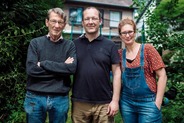 Drie personen staan voor een tuin