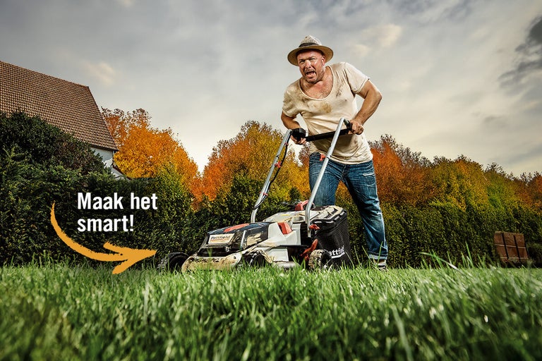 Man maait gazon met een grasmaaier in de tuin