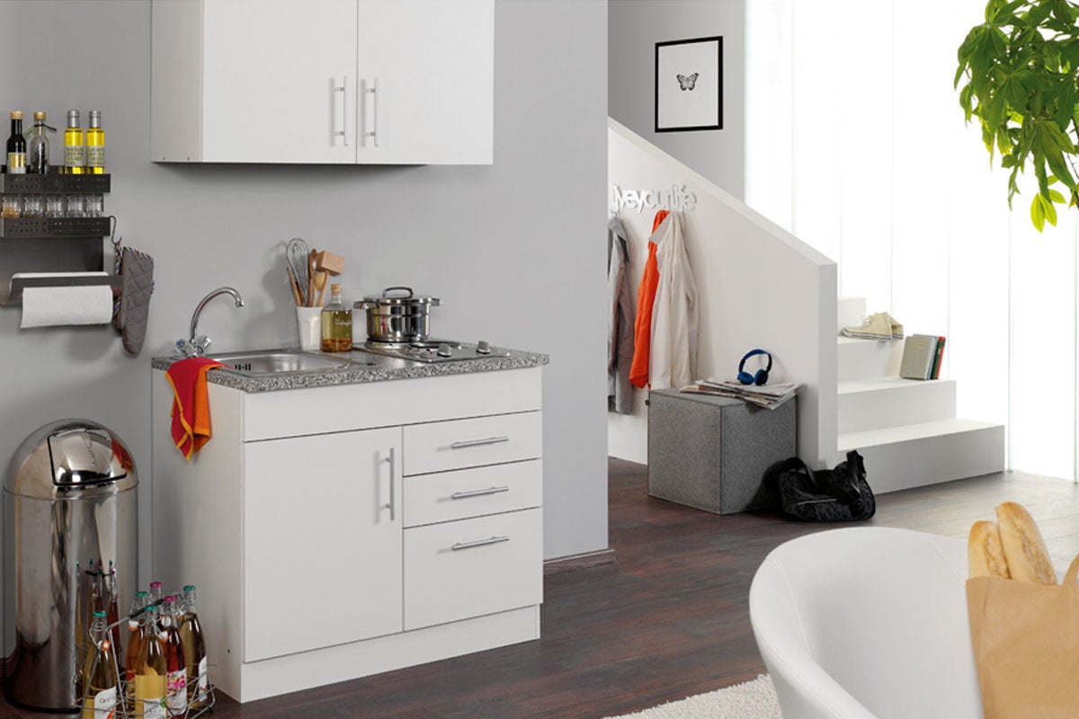 Keukenblok met gootsteen, kookplaat en opbergruimte in een modern ingericht appartement.