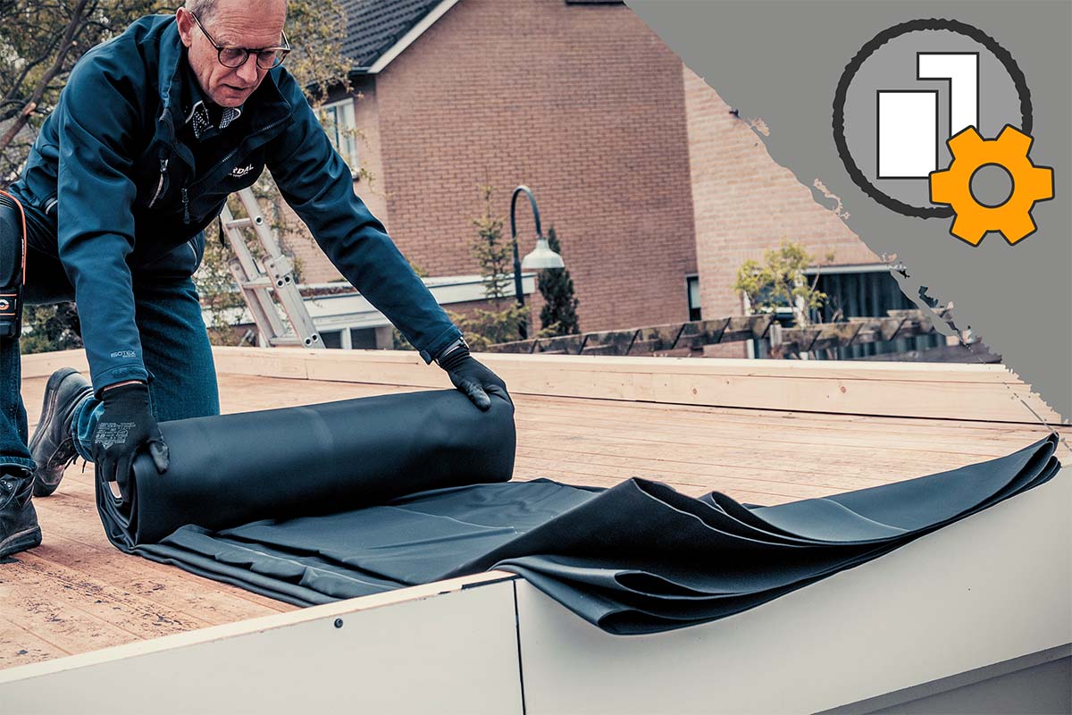 Vakman rolt zwarte EPDM dakbedekking uit op een houten constructie op het dak.