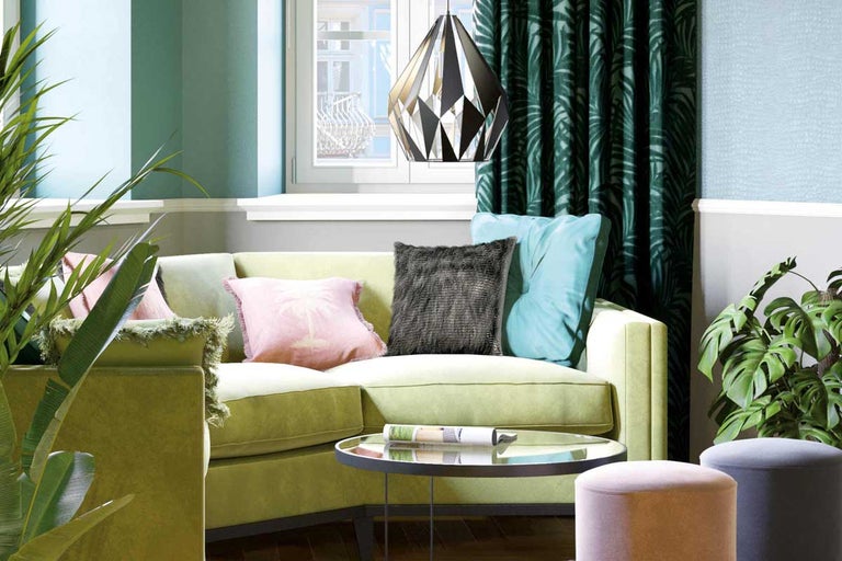 Woonkamer met groene bank, kussens, lamp en planten