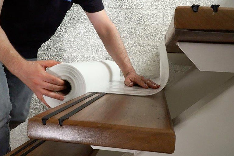 Man legt schildersvlies op een trap.