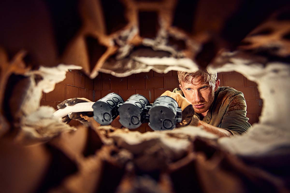 Vakman installeert inbouwdozen in een muuropening voor elektrische installatie.