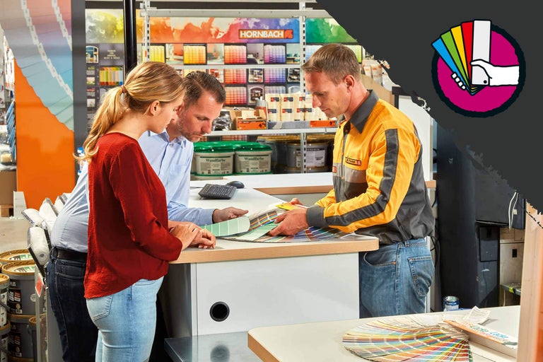 Een Hornbach medewerker adviseert een stel bij het kiezen van een kleur.