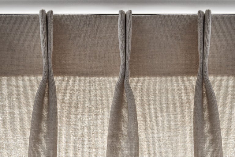 Close-up van een beige gordijn met plooiband.