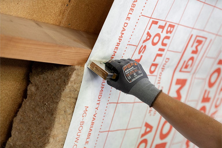 Aanbrengen van een dampremmende folie met een tacker op een dakconstructie