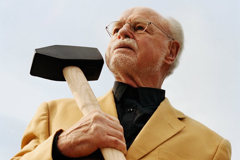 Portret van een man met bril die een hamer vasthoudt