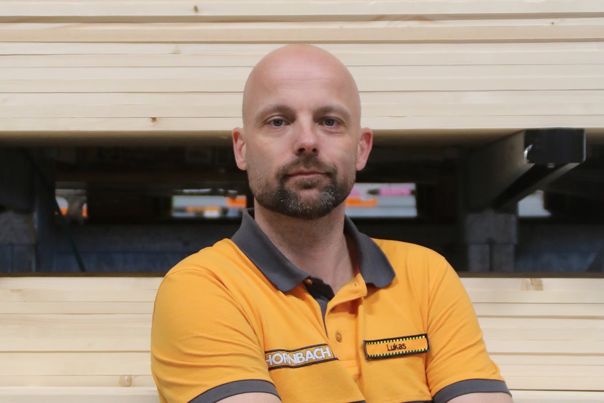 Hornbach medewerker Lukas voor gestapelde houten planken