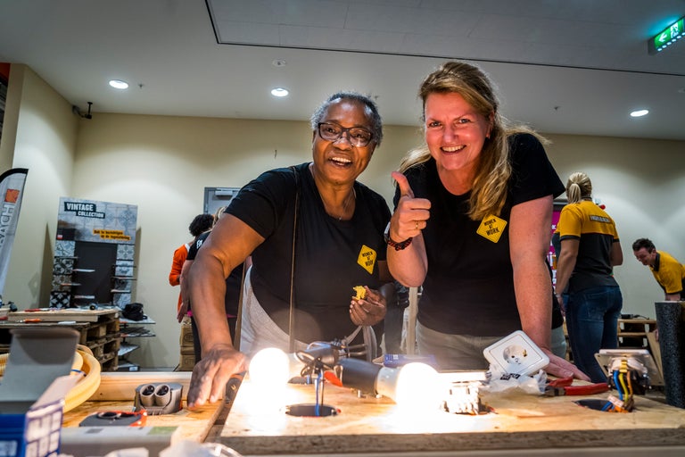 Twee vrouwen demonstreren elektrische installaties op een werkbank bij Hornbach.