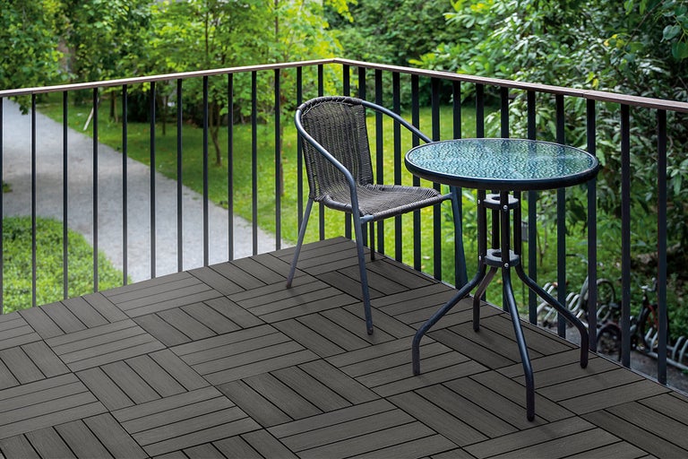 Afbeelding van een balkon met stoel, tafel en terrastegels