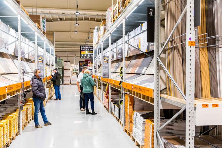 Klanten in de Hornbach-winkel bekijken vloerbedekking in rekken