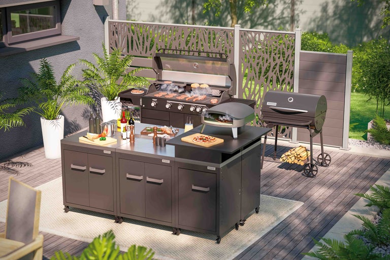 Buitenkeuken met barbecue, pizzaoven, werkblad en opbergkasten op een terras.
