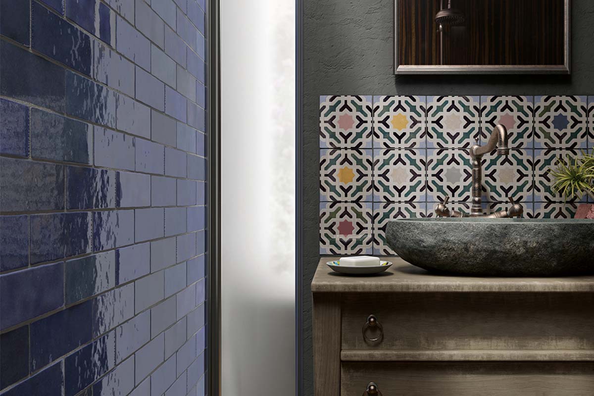 Badkamer met blauwe tegels en wastafel op houten commode