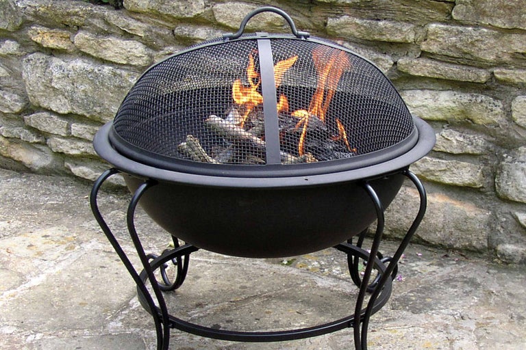 Metalen vuurkorf met vonkenvanger en brandend hout