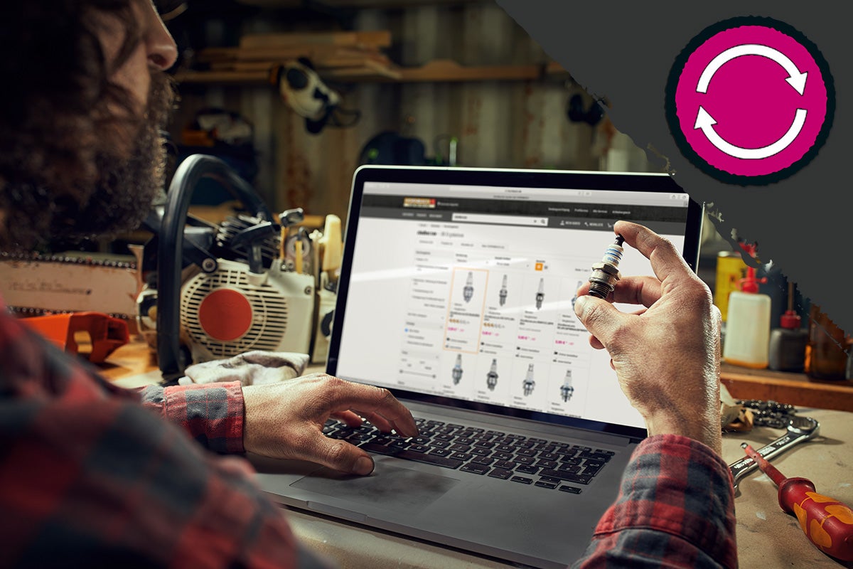 Een persoon vergelijkt een bougie met de online beschikbare producten op een laptop. Op de achtergrond staat een kettingzaag.