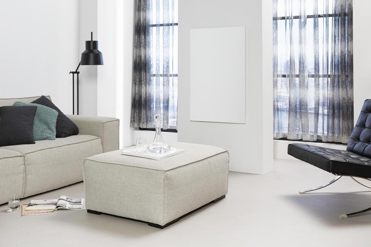 Woonkamer met bank, fauteuil, hocker en radiator
