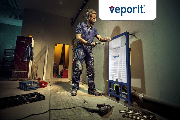 Een installateur monteert een inbouwreservoir van Veporit in een casco.