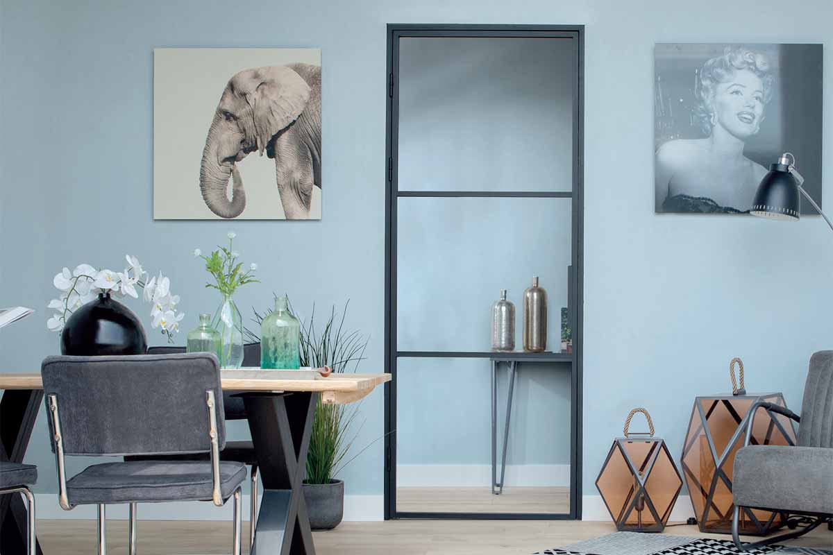 Woonkamer met eettafel, stoelen en een deur met glazen paneel