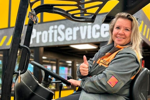 Een vrouw zit op een vorkheftruck en steekt haar duim op voor Hornbach ProfiService.