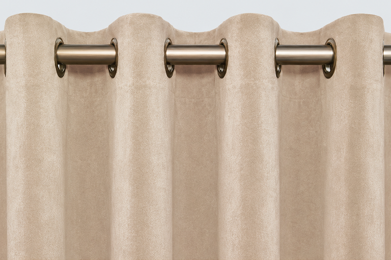 Beige gordijn met metalen ringen aan een gordijnroede, stof in suède-look.