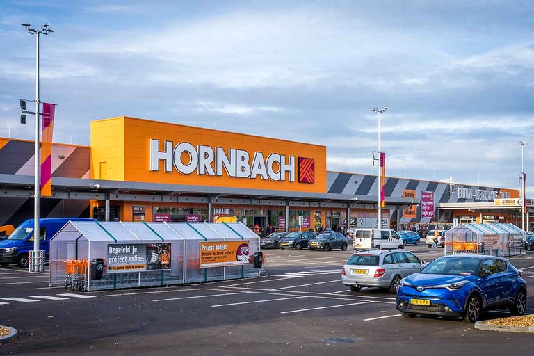 Hornbach bouwmarkt gebouw met parkeerplaats en winkelwagen stalling.