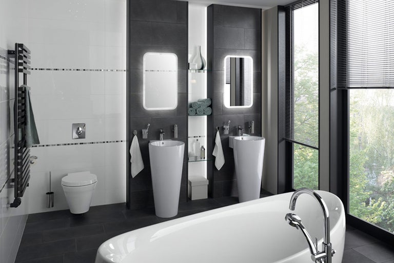 Lichte badkamer met bad, wastafel, spiegel en radiator