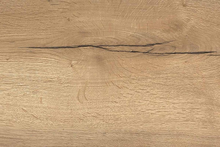 Detailweergave van een houten oppervlak met eikendecor, nerven en een karakteristieke barst.