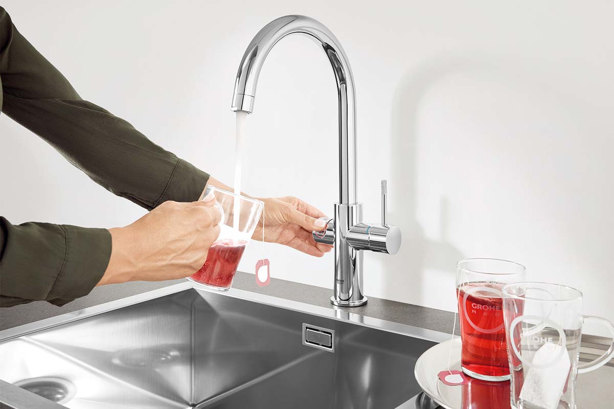 Persoon vult water in glas onder chromen keukenkraan