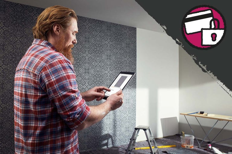 Een man plant een renovatie met een tablet: veilige online betaling.
