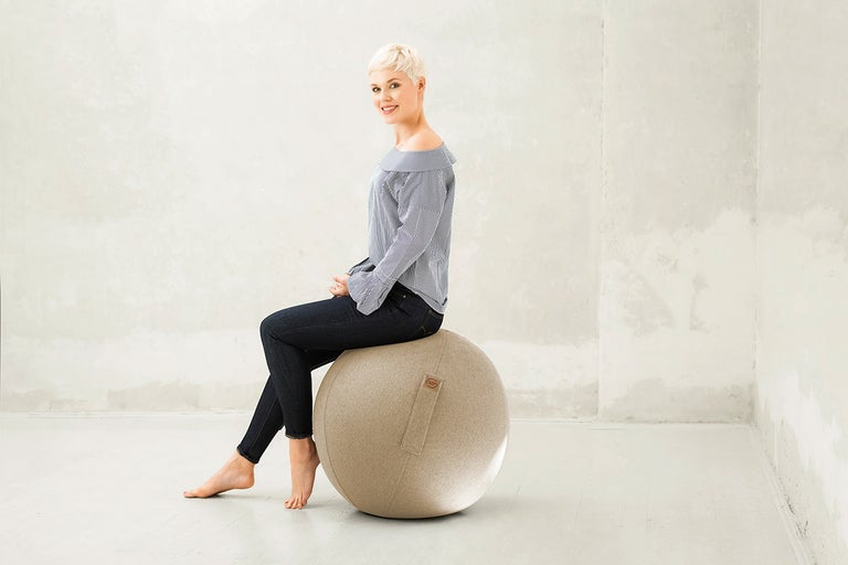 Vrouw zit op een gymnastiekbal op kantoor