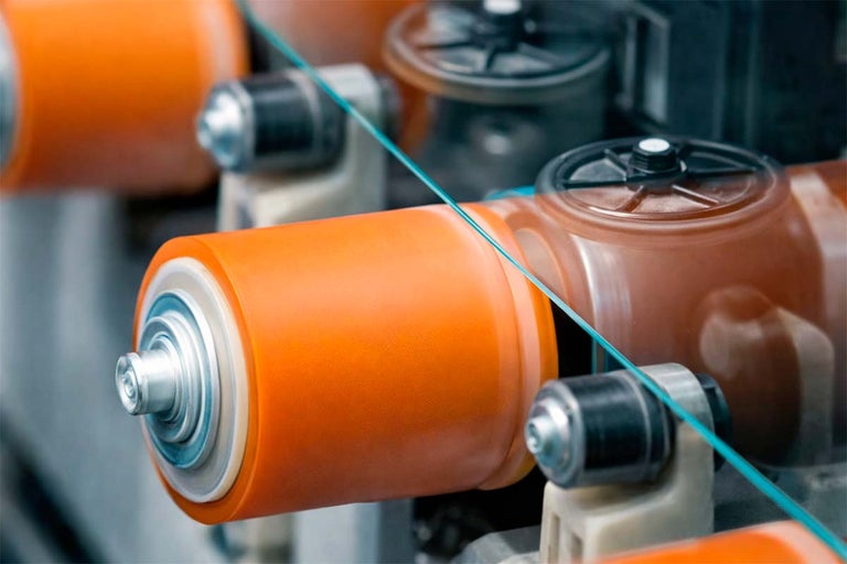 Detailopname van oranje rubberrollen in een industriële omgeving