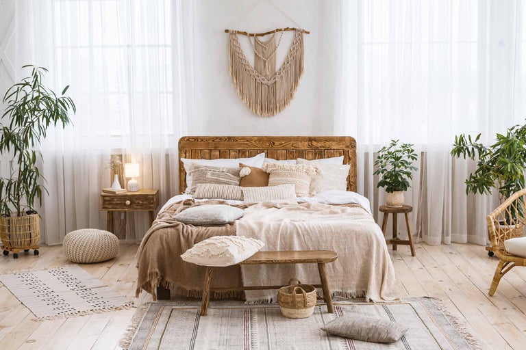 Lichte slaapkamer met houten bed, nachtkastje en kamerplanten voor een vriendelijke sfeer.