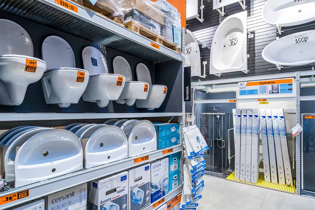 Stellingen met toiletten, wastafels en douchecabines in een bouwmarkt