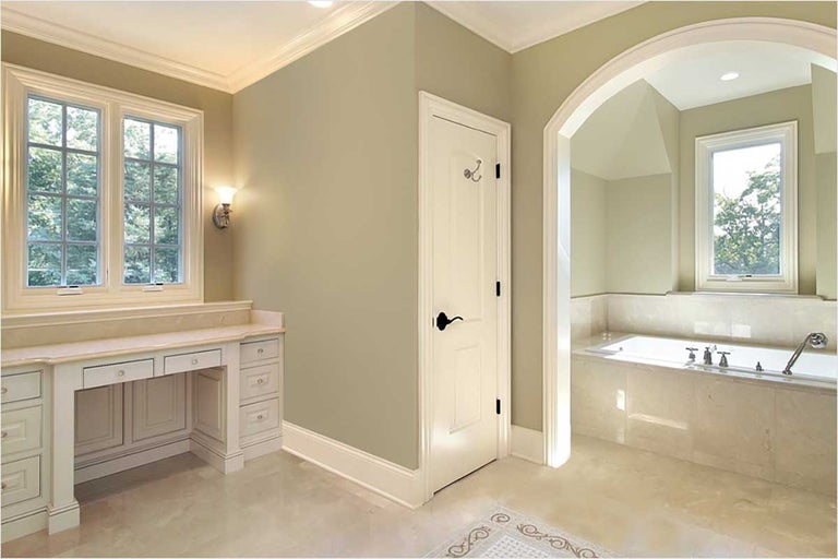 Badkamer met wastafel, raam, deur en bad.