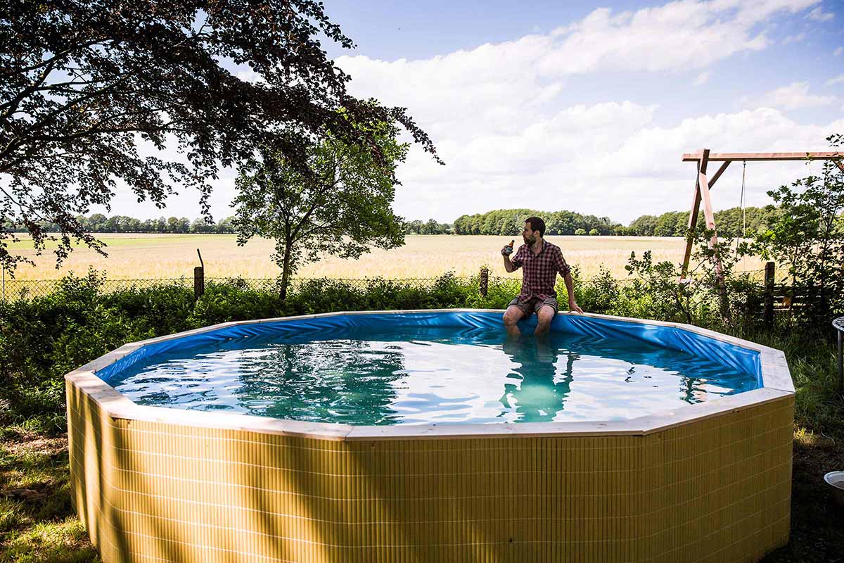 Opzetzwembad in de tuin met een man aan de rand