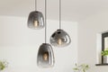 Hanglamp met drie glazen lampenkappen in verschillende vormen voor een moderne interieurverlichting.
