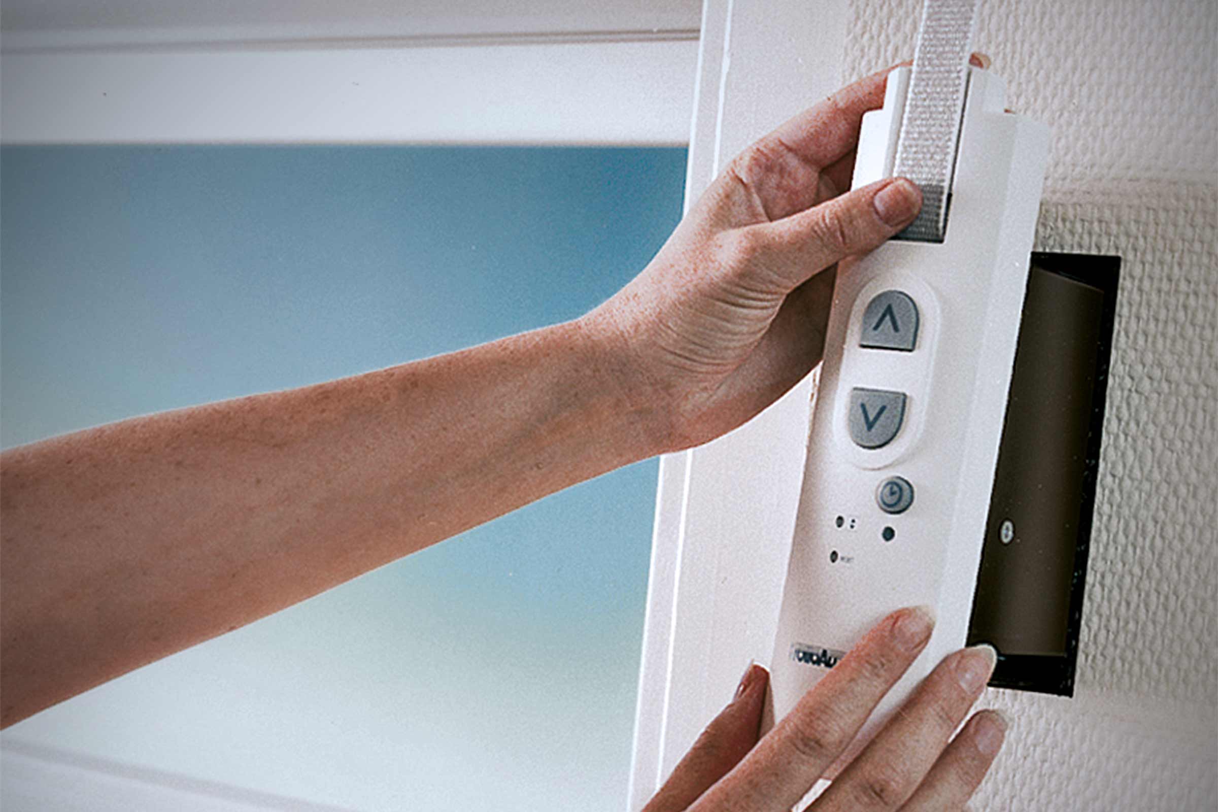 Persoon bedient elektronische riemwikkelaar voor rolluiken