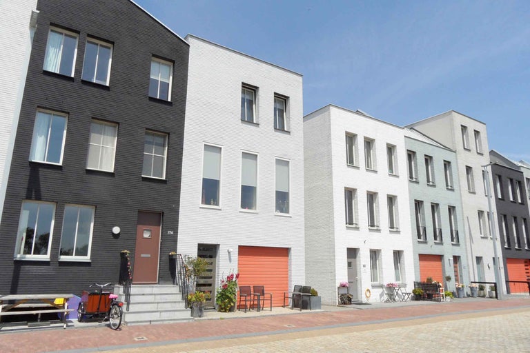 Rij rijtjeshuizen met diverse gevels aan een straat