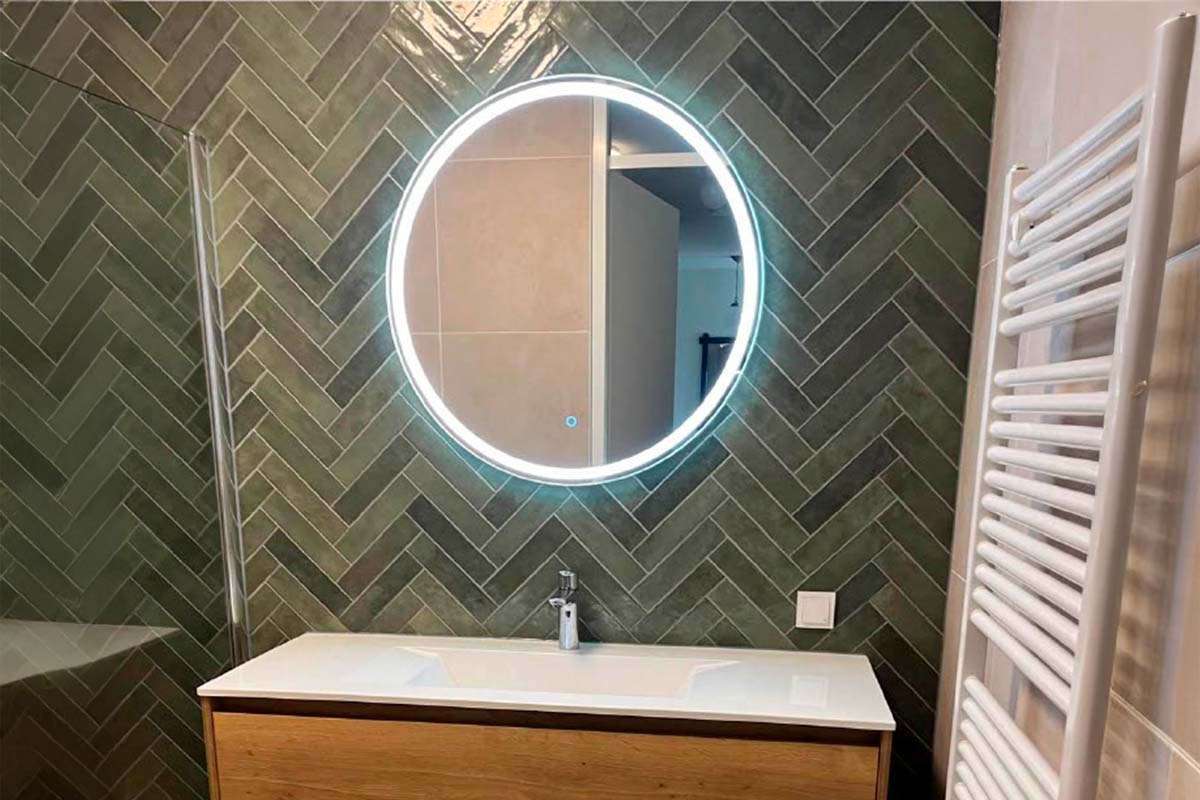 Badkamer met wastafel, spiegel met verlichting en radiator