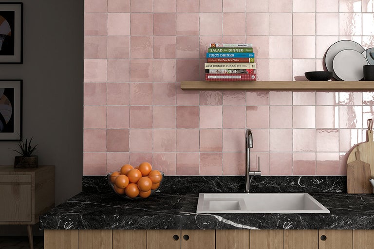 Keukenscène met betegelde wand, werkblad en gootsteen.