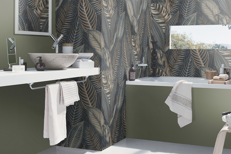 Moderne badkamer met een waskom in steenlook op een wit blad, een ligbad en behang met botanisch bladerpatroon.