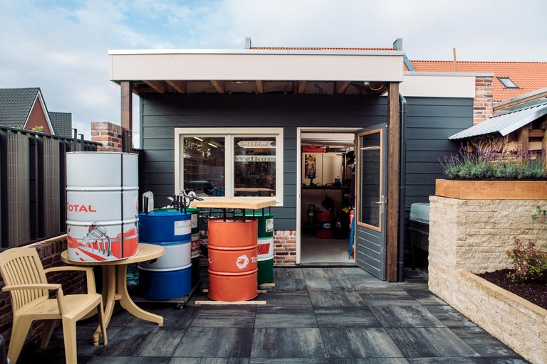 Buitenruimte met bestrating, tuinhuis en versierde vaten